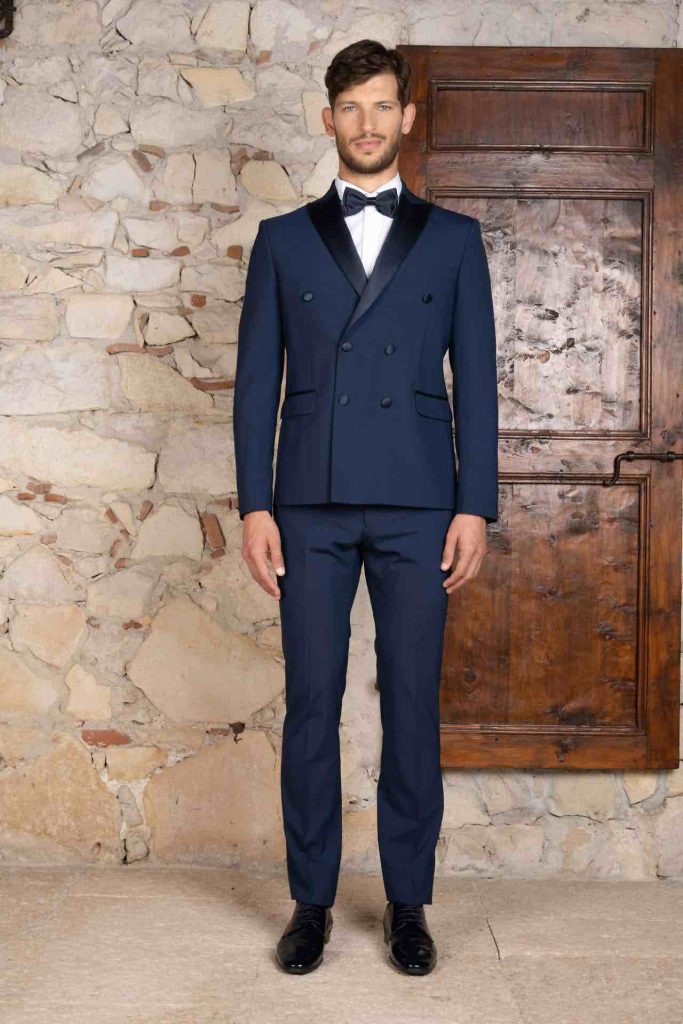In questa foto il modello posa nella Tenuta Ugolini indossando un vestito da sposo blu con giacca doppio petto e revers a lancia: dettagli, questi, in raso ton sur ton
