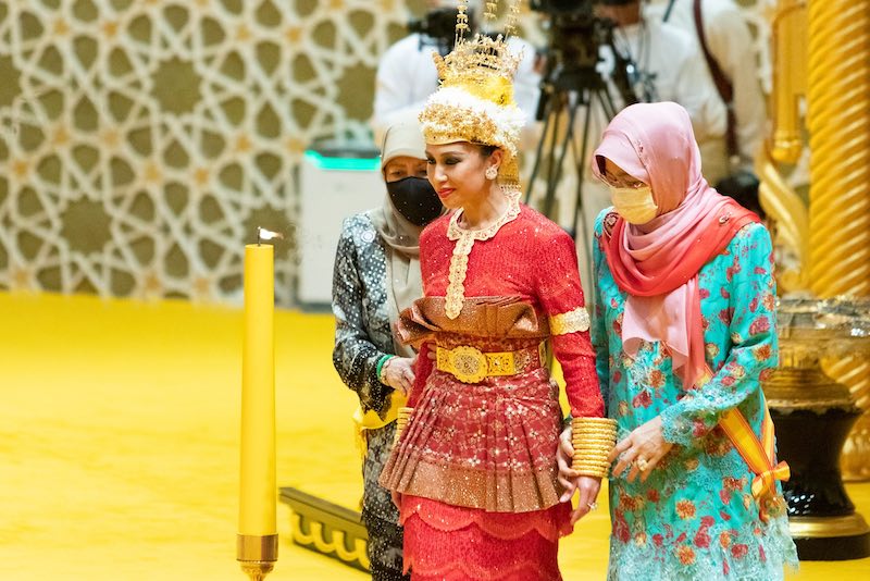 In questa foto la principessa Azemah in abito rosso con dettagli in oro accompagnata da due donne con velo 