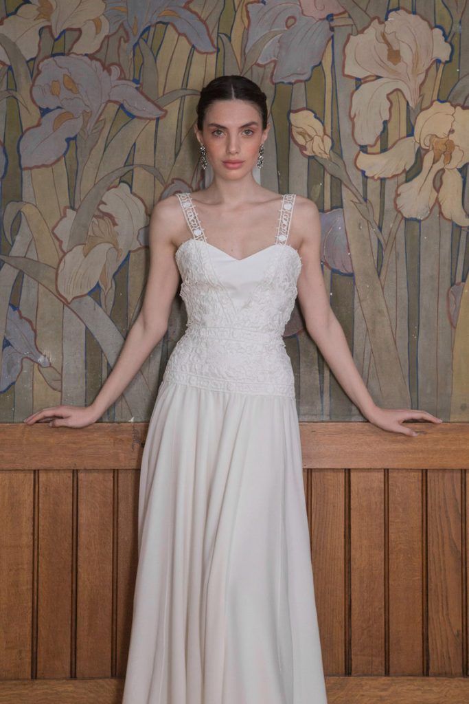 In questa foto una modella indossa un abito da sposa More scivolato in crepe con corpetto in pizzo macramè 