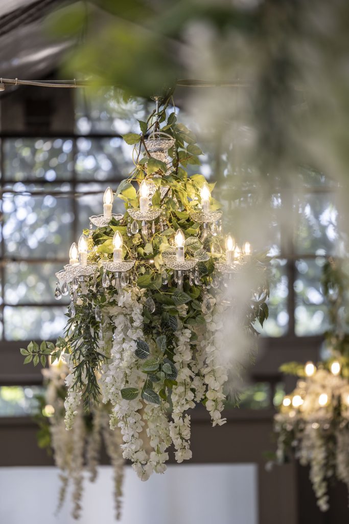 In questa foto i lampadari da soffitto di cristallo ricoperti di fiori delle nozze di Mariavittoria e Claudio