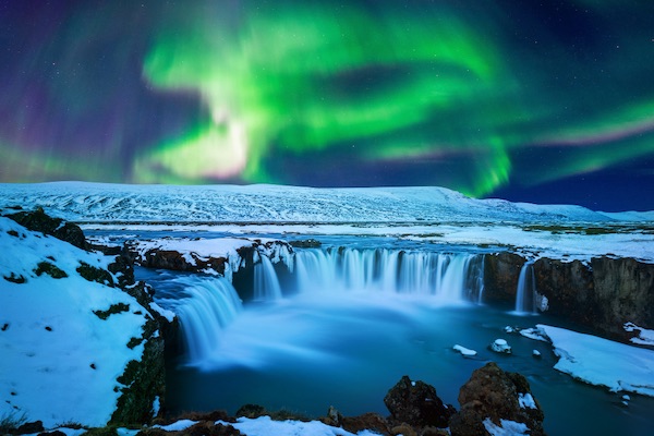 In questa foto l'aurora boreale alla cascata Godafoss, in Islanda. Si tratta di uno di quei viaggi di nozze 2023 più insoliti ma stupefacenti
