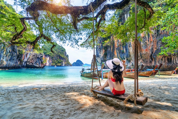 In questa foto una ragazza in costume seduta su una spiaggia dell'Isola di Ko Lao, a Krabi, in Thailandia