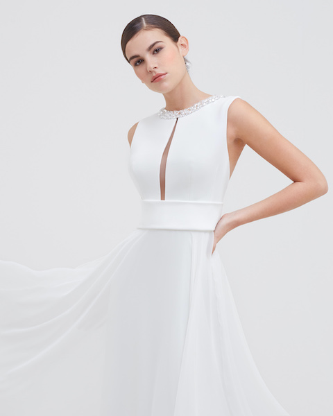 In questa foto una modella indossa un abito da sposa semplice ed elegante di Angela Pascale 2023
