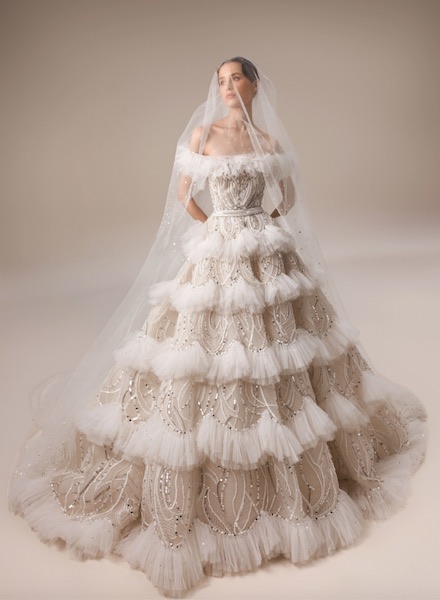 In questa foto una modella posa indossando un abito da sposa con microbalze di Elie Saab 2023