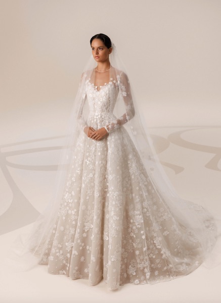 In questa foto una modella indossa un abito da sposa ricamato in filo di seta, con ramage floreali su tutto il tessuto