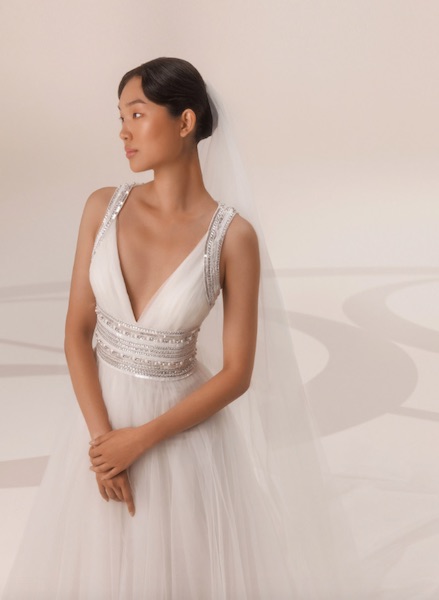 In questa foto, una modella fotografata tre quarti per mostrare i dettagli sparkling dell'abito da sposa