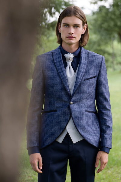 In questa foto un modello indossa un abito da sposo 2023 con singolare giacca in Pied de poule blu