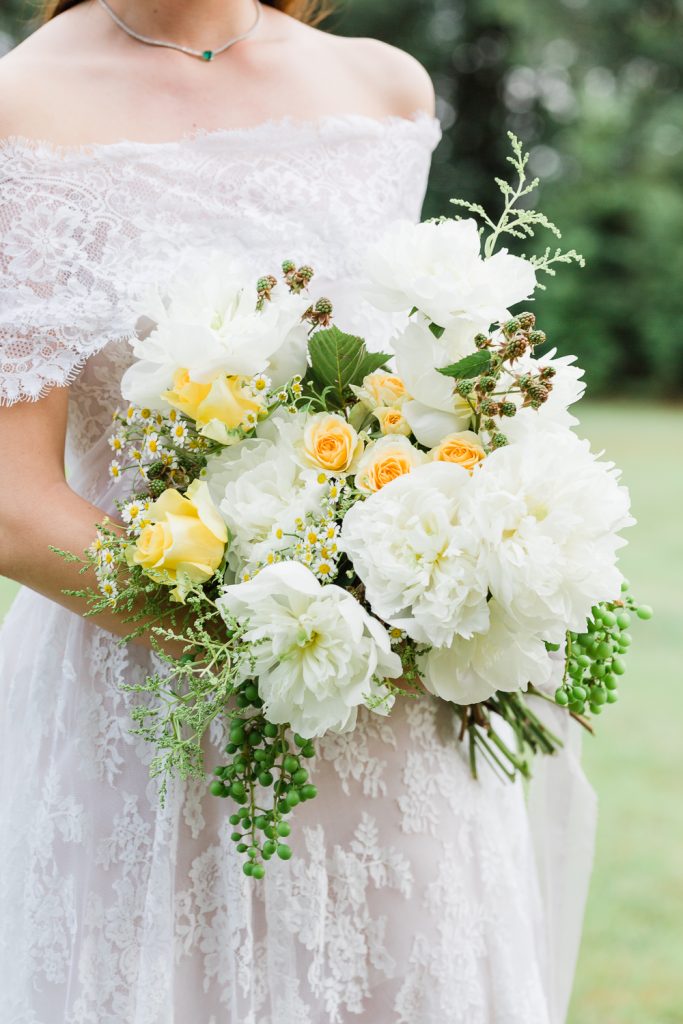In questa immagine un bouquet sposa 2023 con peonie bianche e roselline gialle. 