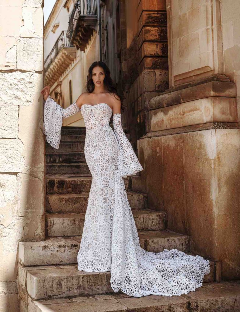 In questa immagine un abito da sposa Claudio Di Mari 2023 interamente in pizzo con maniche staccabili. 