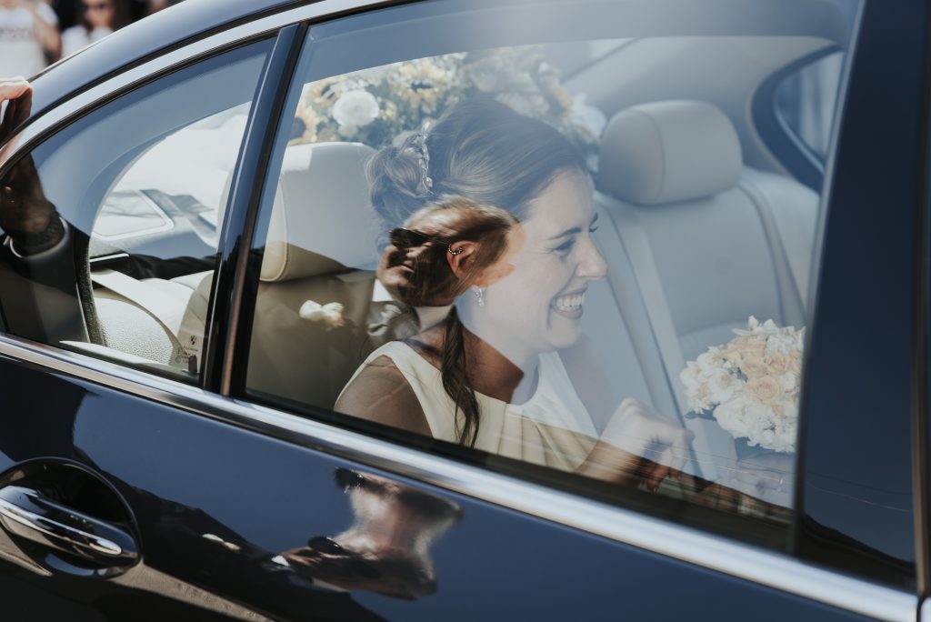 In questa immagine lo scatto di Lumens Studio che ritrae la sposa mentre è in macchina e sta per arrivare in chiesa