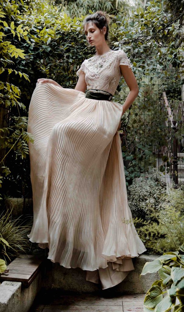 In questa immagine un abito da sposa Elisabetta Delogu 2023 con gonna plissé e corpetto ricamato. 