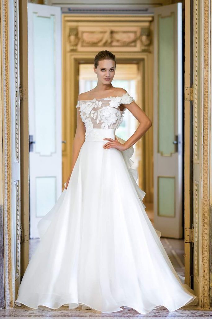 In questa foto una modella indossa un abito da sposa Stefano Blandaleone 2023 con gonna di organza di seta e bustier illusion ricamato con fiori 3D