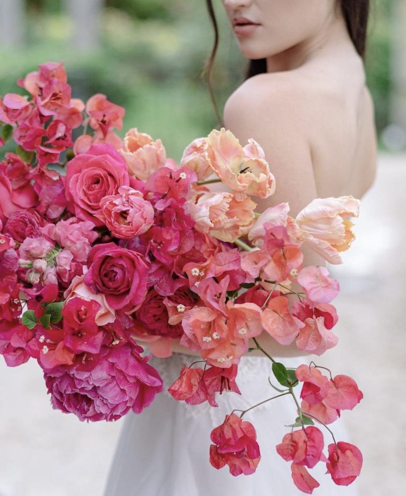 In questa immagine un bouquet sposa 2023 con la bougainvillea, peonie e rose, nella tonalità del fucsia. 