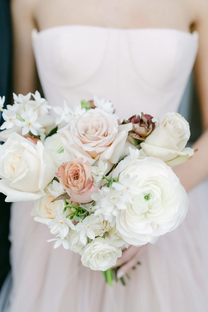 In questa foto un mazzo di fiori bianco con delle roselline rosa tra le tendenze del nuovo anno. 