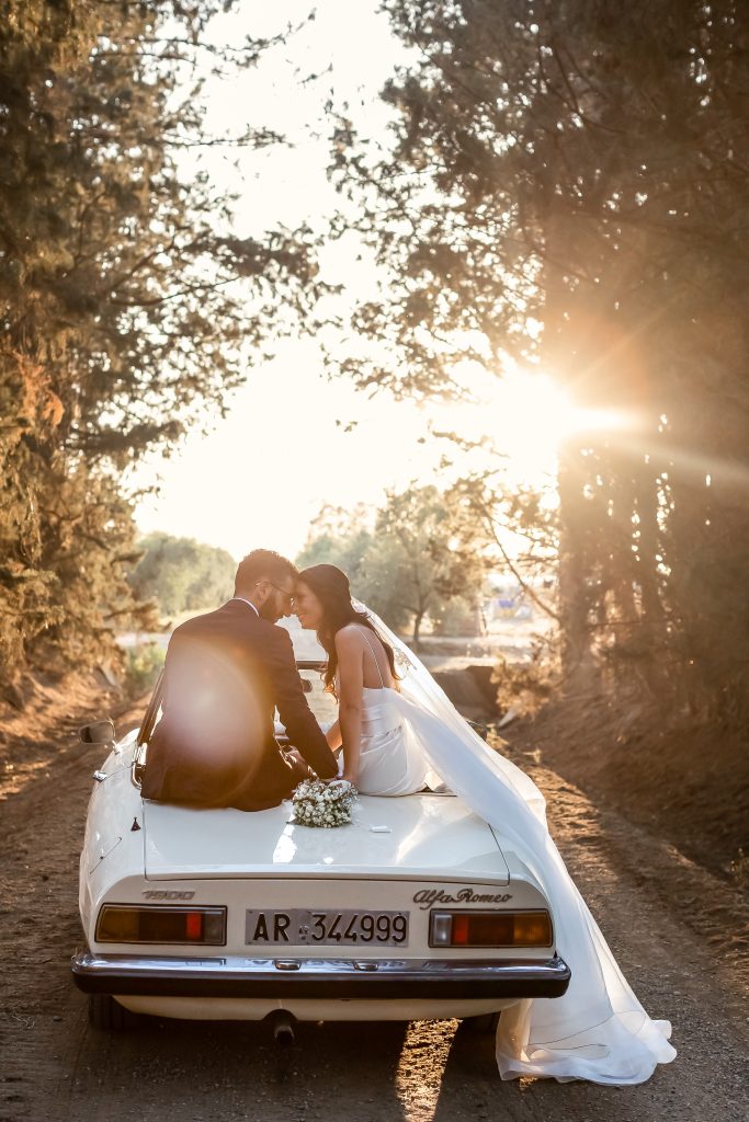 In questa immagine lo scatto di Morlotti Studio che ritrae gli sposi mentre si guardano negli occhi seduti sulla macchina