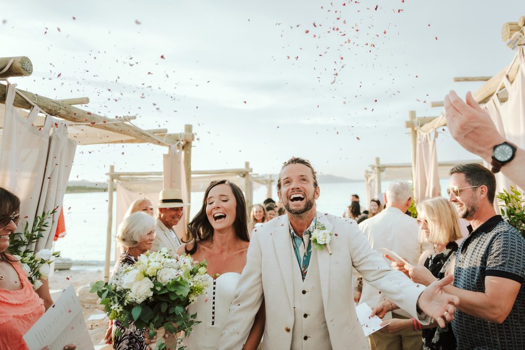 In questa immagine lo scatto di Paolo Salvadori che ritrae gli sposi che sorridono in spiaggia e che fa parte delle 50 foto di matrimonio più belle del 2022