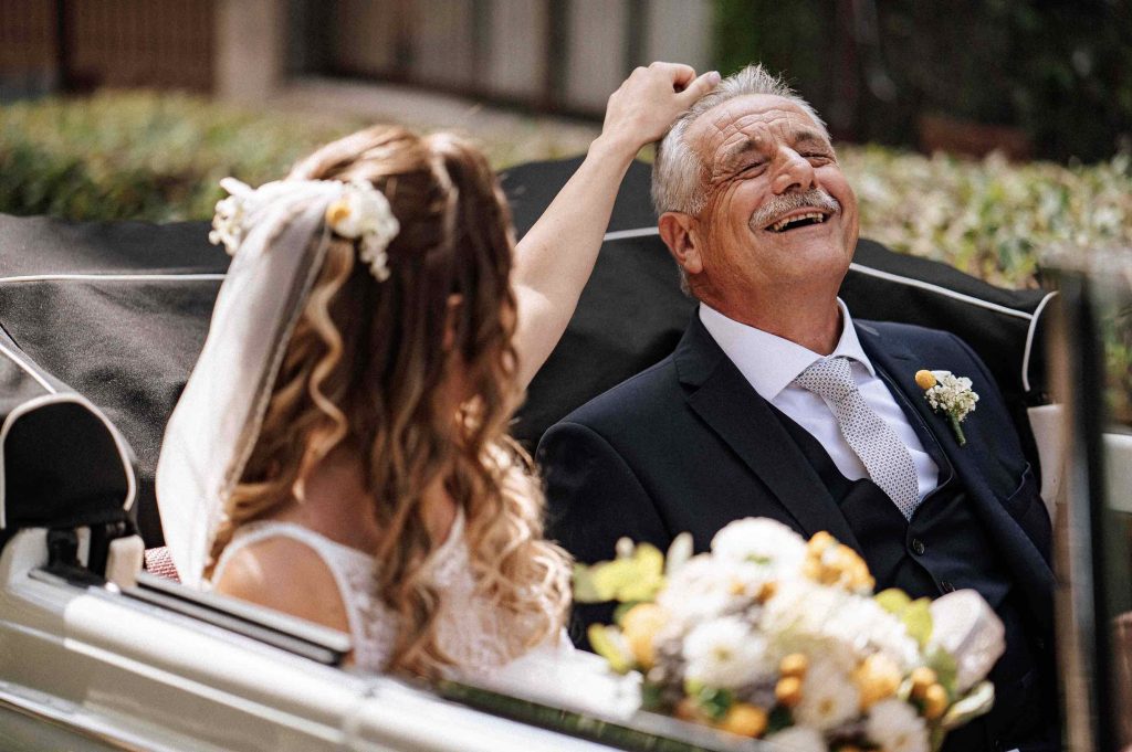 In questa immagine lo scatto di Alessandra Massara che ritrae la sposa mentre si sistema i capelli al papà
