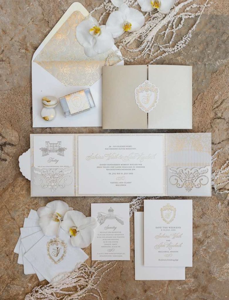In questa foto una wedding stationery nei colori dell'oro e del bianco
