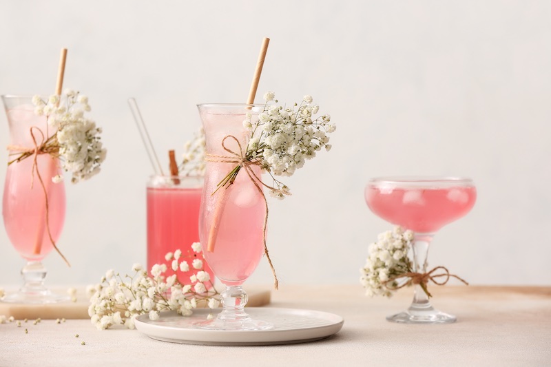 In questa foto cocktail del matrimonio di colore rosa decorati con piccoli bouquet di gypsophila bianca