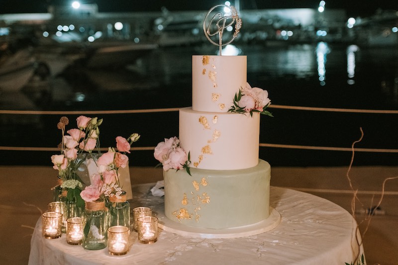 In questa foto una torta nuziale a tre piani nei toni del verde salvia, del bianco e dell'oro