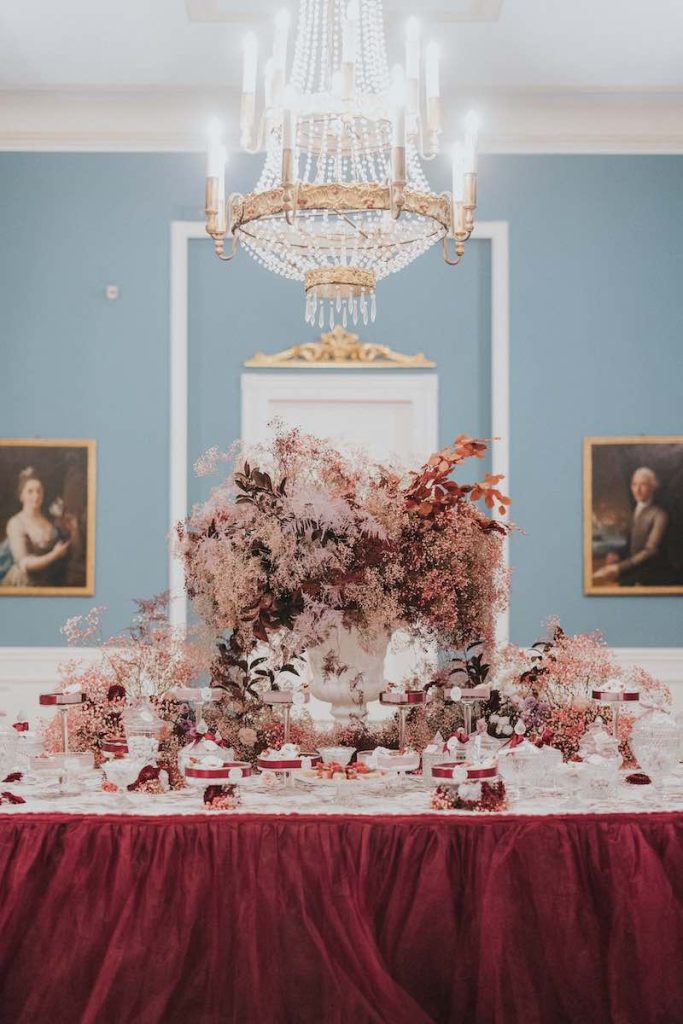 In questa foto l'allestimento di un buffet di matrimonio con una tovaglia colore Viva Magenta e fiori nei toni del rosa