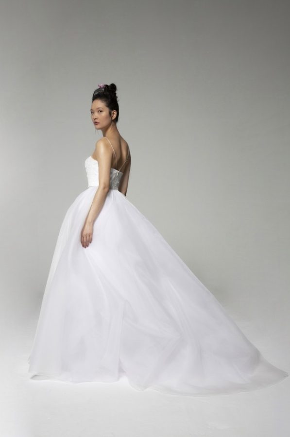 In questa foto una modella ritratta di profilo indossa l'abito Tosca Spose 2023 "Olympia" con gonna in organza e corpetto rigido