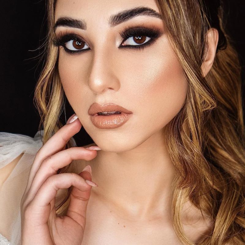 In questa foto una modella posa mostrando in primo piano un trucco sposa smokey eyes nei toni del marrone abbinato ad un rossetto nude satinato