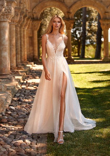 In questa foto una modella indossa un abito da sposa della collezione 2023 di Pronovias Essence of Love