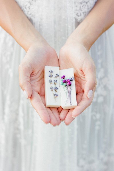 In questa foto una modella tiene tra le mani i saponi artigianali profumati di Just Tuscany. Bellissima idea di nozze, che strizza l'occhio alla sostenibilità