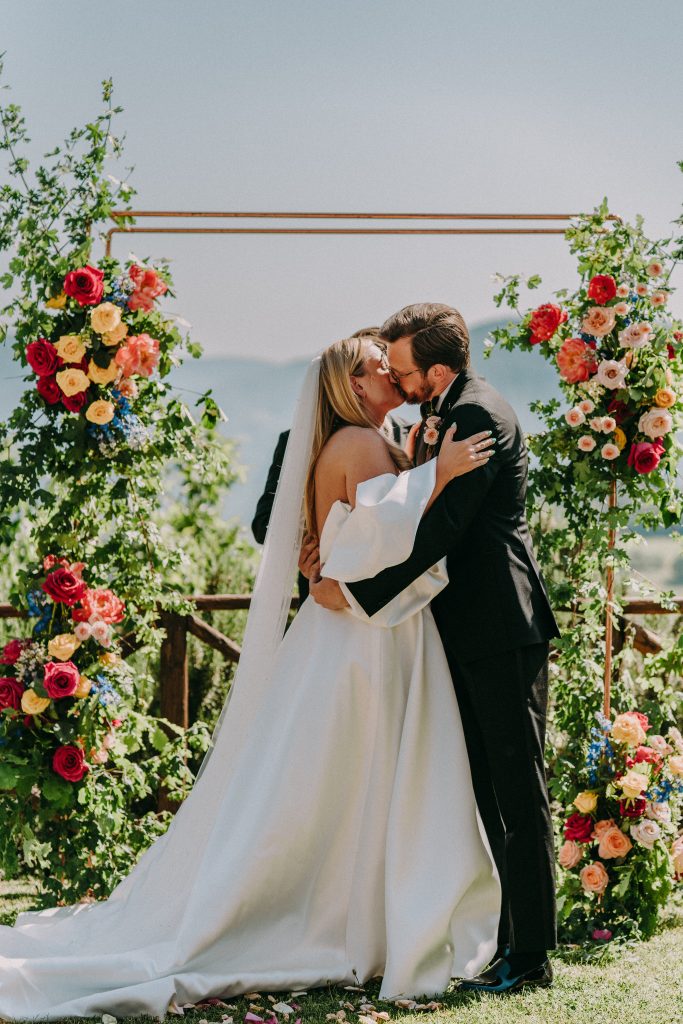 In questa immagine un allestimento floreale matrimonio 2023 per una cerimonia all'aperto con maxi fiori colorati.