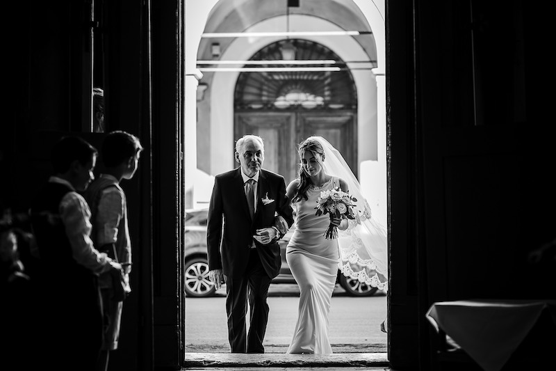 In questa foto in bianco e nero di Nicola Tanzella una sposa che entra in chiesa con il papà al braccio