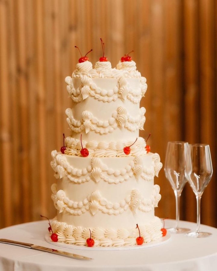 In questa foto una Lambeth Cake per matrimonio decorata con glassa di colore bianco e ciliegine rosse glassate 