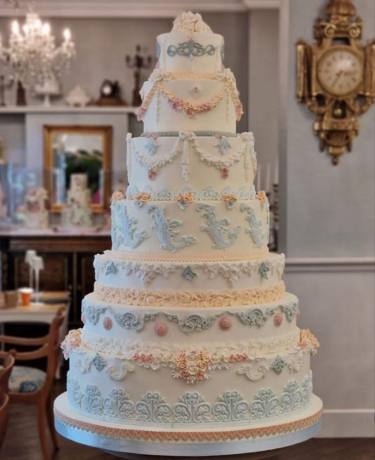 In questa foto una torta per matrimonio a piani decorata con arabeschi di zucchero di colore celeste e rosa