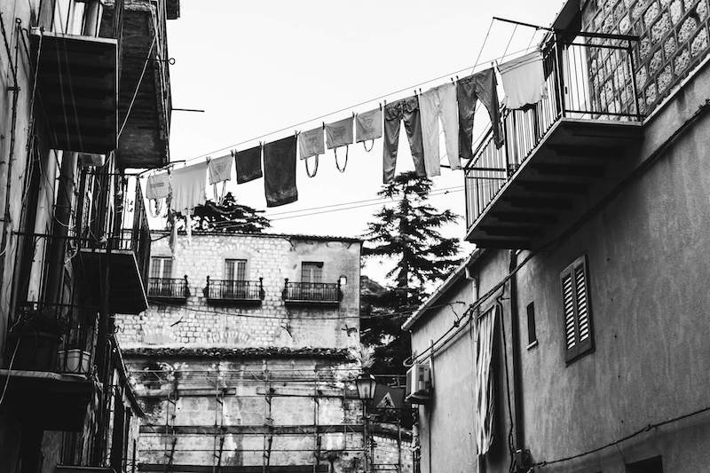 In questa foto in bianco e nero di Vincenzo Aluia una fila di panni stesi tra i balconi di Petralia Sottana
