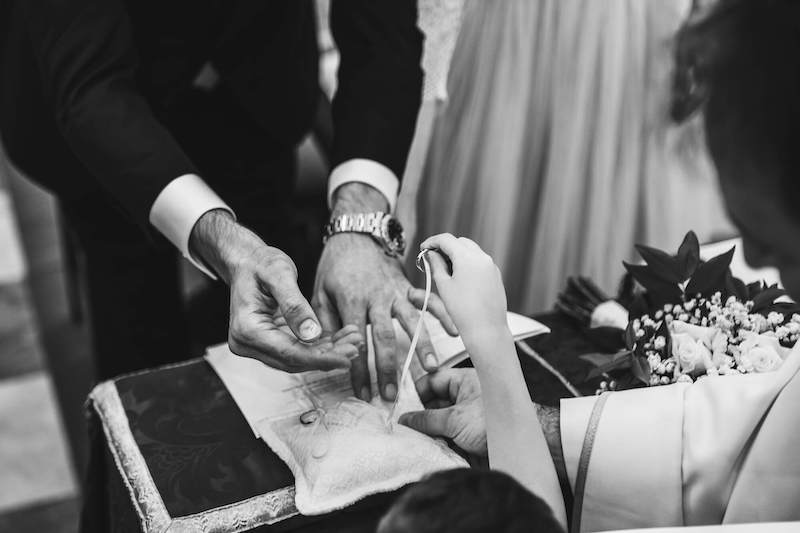 In questa foto in bianco e nero di Vincenzo Aluia un paggetto porge le fedi legate al cuscino portafedi allo sposo