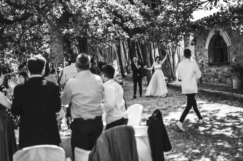 In questa foto in bianco e nero di Vincenzo Aluia gli sposi arrivano alla location del ricevimento accolti da tutti gli ospiti