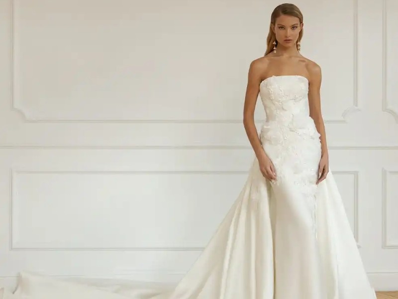 In questa foto un abito da sposa Eva Lendel 2023 modello a sirena in mikado con fiori 3D e sovragonna staccabile