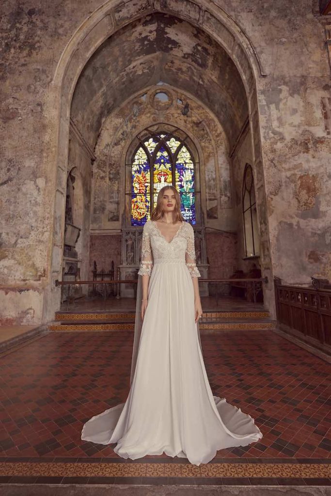 In questa foto una modella indossa un abito da sposa Temperley Bridal 2024 con corpetto ricamato, scollo a V, maniche a tre quarti a corolla e gonna 
fluida in chiffon