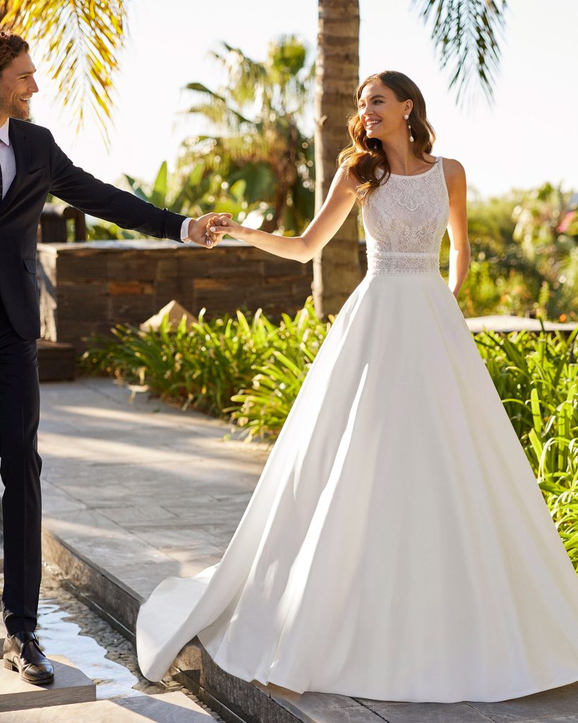 In questa immagine un abito con corpetto in pizzo e gonna in seta della collezione sposa Adriana Alier 2023