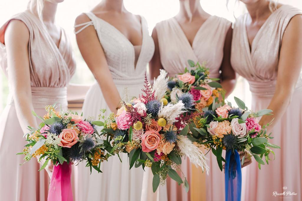 In questa foto quattro damigelle inquadrate dal collo in giù mostrano i loro bouquet di Idee da Sogno