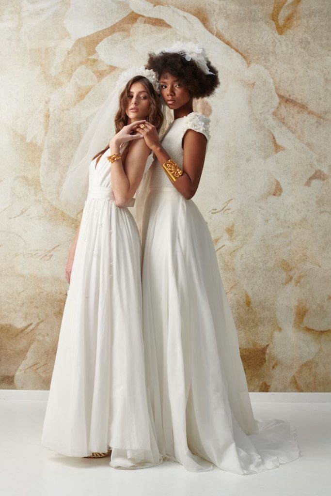 In questa foto due modelle posano indossando due abiti da sposa scivolati dalle linee pulite della collezione Natural Choice Le Fate Milano 2024