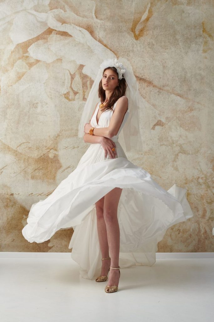 In questa foto una modella indossa un abito da sposa scivolato con velo abbinato della collezione Natural Choice Le Fate Milano