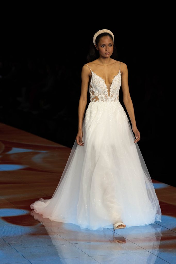 In questa immagine un abito da sposa Modeca 2024 con corpetto in pizzo. 