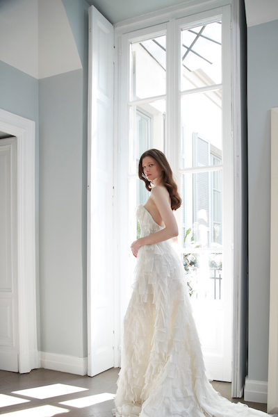 In questa foto una modella indossa un abito da sposa con una particolarissima lavorazione a microbalze del tessuto