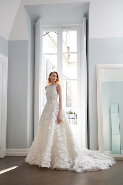 In questa foto una modella indossa un abito da sposa di Peter Langner Milano 2024 con una lavorazione a microbalze del tessuto