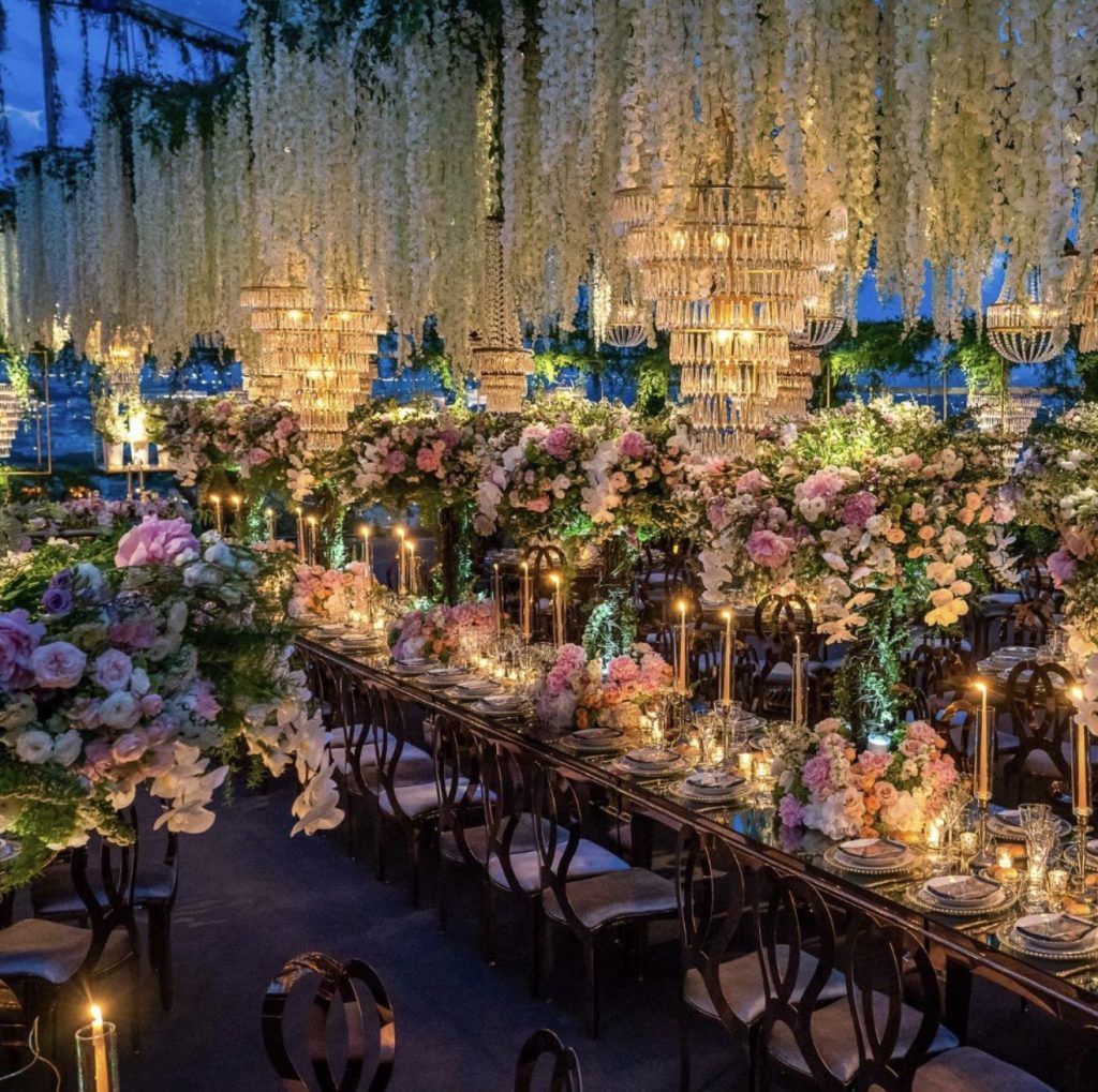 In questa immagine un allestimento da sogno con chandelier e tantissime decorazioni floreali.  