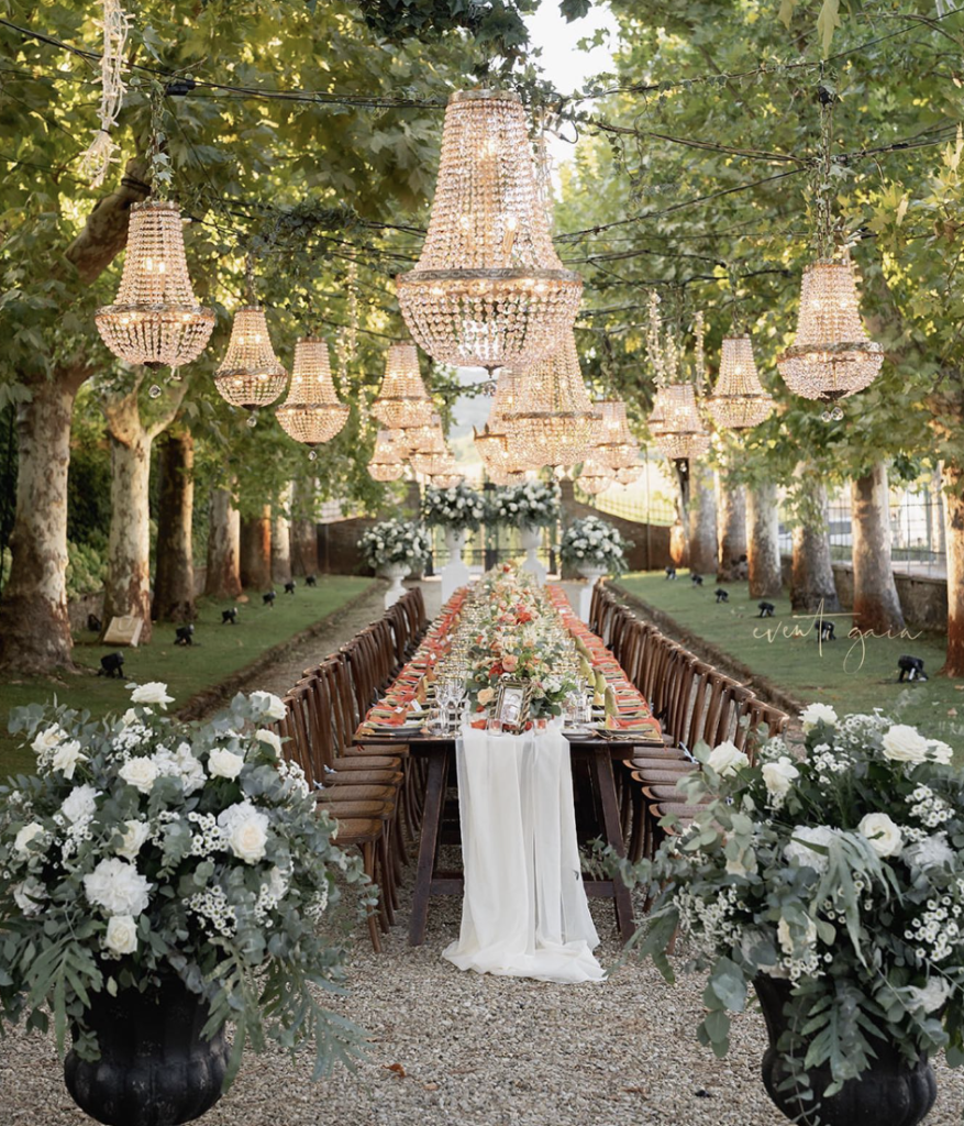 In questa immagine un allestimento da sogno, immerso nella natura, con chandelier sospesi.