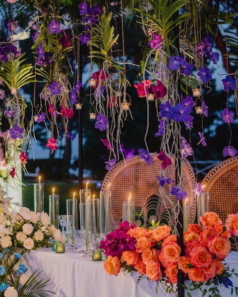 In questa immagine un allestimento da sogno con decorazioni floreali sospese e tanto colore. 