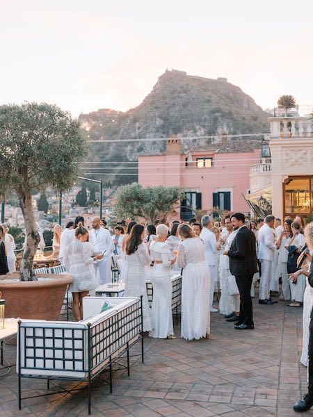 In questa foto gli ospiti della 40esima edizione di Engage, a Taormina, su una delle terrazze del Grand Hotel Timeo durante un cocktail e tutti vestiti di bianco