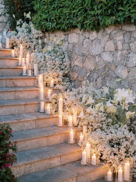 In questa foto una delle scalinate del Grand Hotel Timeo, hotel del gruppo Belmond a Taormina, illuminata da una serie di candele accese. Lungo le scale anche fiori bianchi